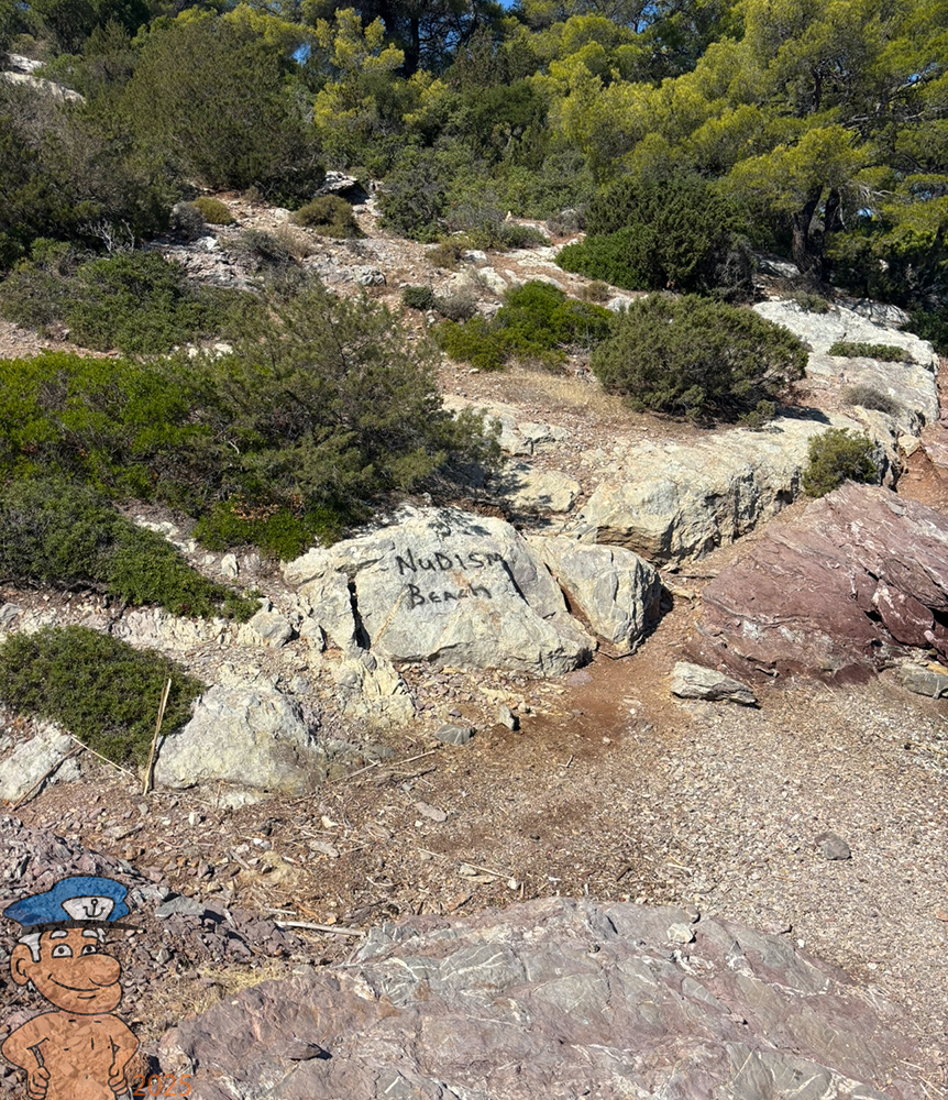 the words "naturist beach" painted by hand on a rock